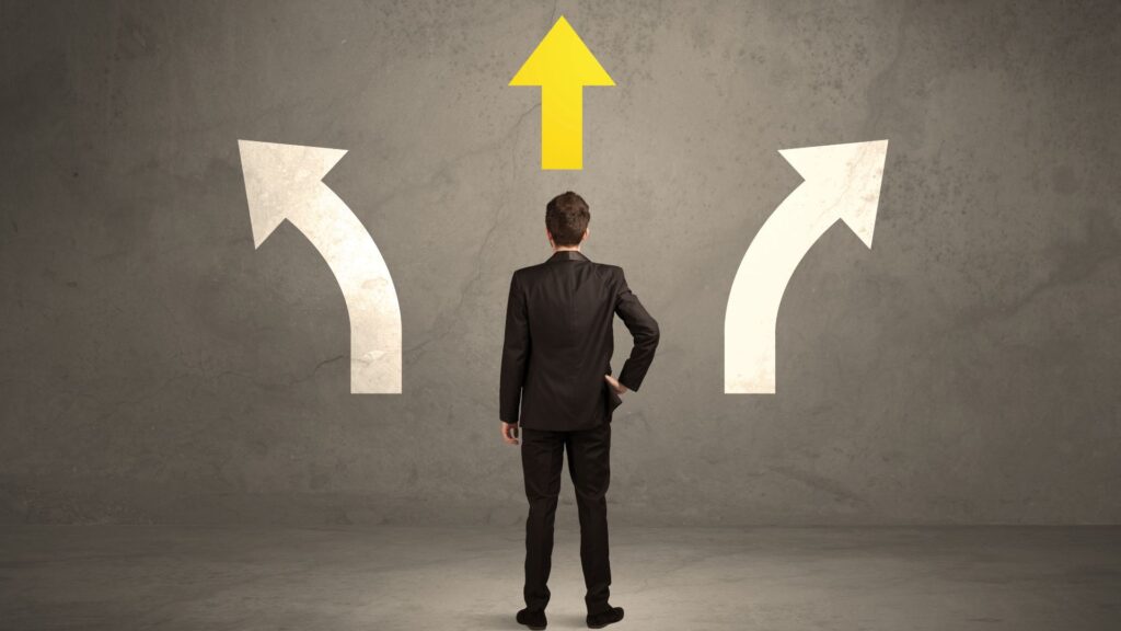 Businessman standing in front of three arrows, deciding the right financial direction
